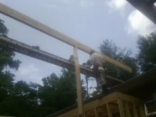 Carpenter setting a ridge beam over a new addition frame — Ice Dam Removal by Roofing Brothers in Thornton